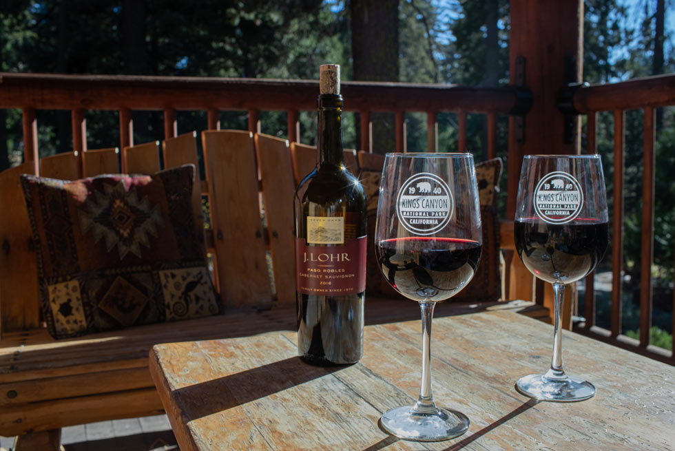 Two glasses of red wine sit on a patio table at John Muir Lodge in Kings Canyon National Park